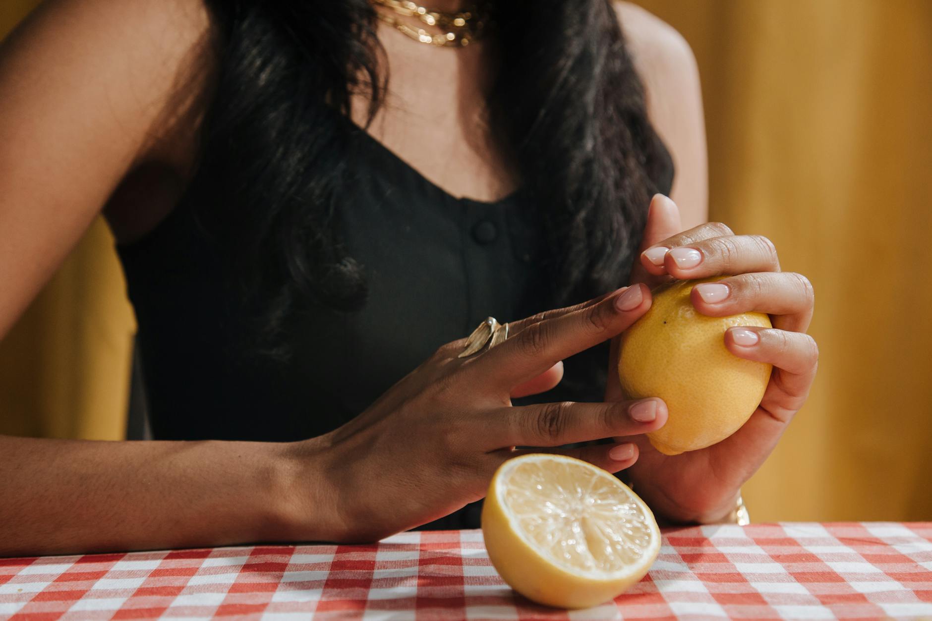 A yellow silicone lemon vibrator surrounded by peeled bananas on a bright yellow background