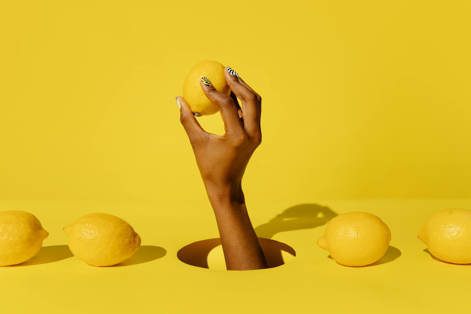 Fresh halved lemons on a soft pink background, symbolizing renewal and gentle approach to pleasure